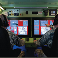 Analysts observing and interacting with software on large computer monitors