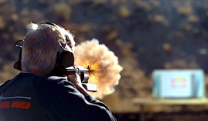 Man shooting long gun as part of ballistics testing.