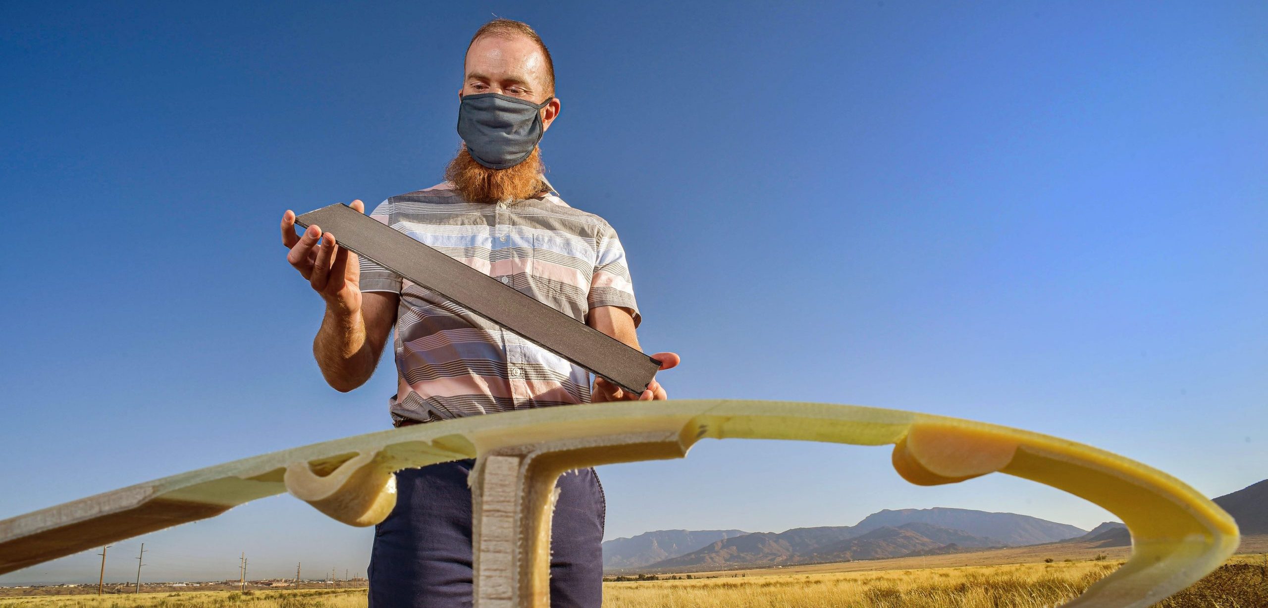 Sandia National Laboratories’ Brandon Ennis holds a carbon fiber plank, a new material that could bring cost and performance benefits to the wind industry.