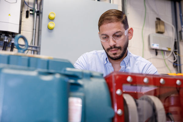 A researcher examines Sandia’s new wind turbine motor, which will allow the distributed energy team to study how real wind farms will behave under a variety of conditions and in different locations.