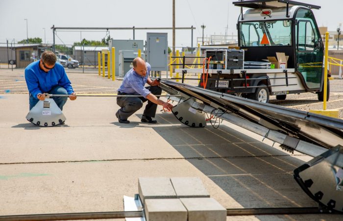 Sandia Technologist William Snyder and Rocking Solar CEO, Darin Palmer, adjust the actuator that moves the tacker rockers.