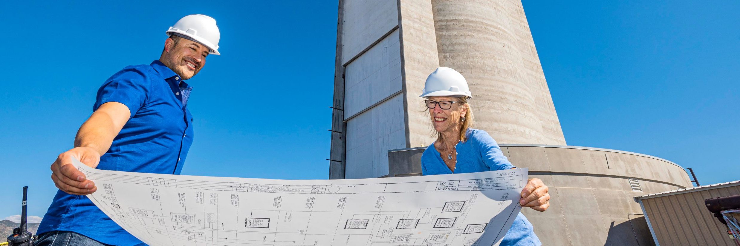 Ken Armijo, left, a Sandia National Laboratories mechanical engineer, and Alice Parsons, a technical librarian, study a historical blueprint for a portion of Sandia’s solar tower, which stands in the background. The document, among tens of thousands of others, is now accessible online to researchers and other interested parties from around the world. (Photo by Randy Montoya)