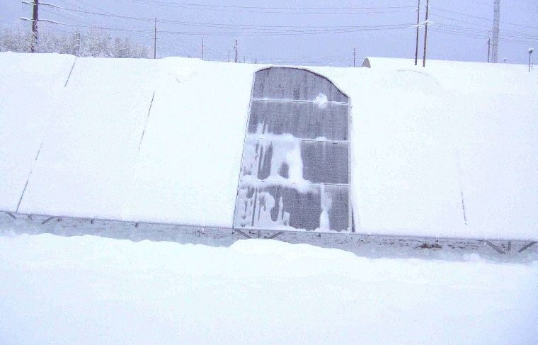 Imagesof snow-covered, photovoltaic panels, where snow has shed from panels with new snowphobic coatings developed at Sandia.