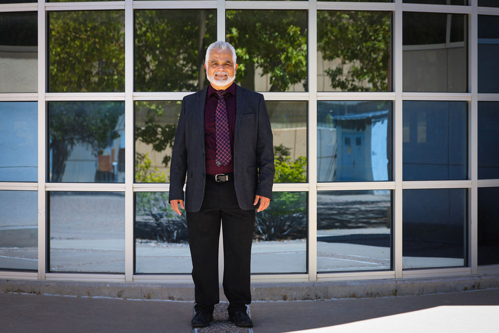 A researcher stands in front of a bank of windows on a bright, sunny day