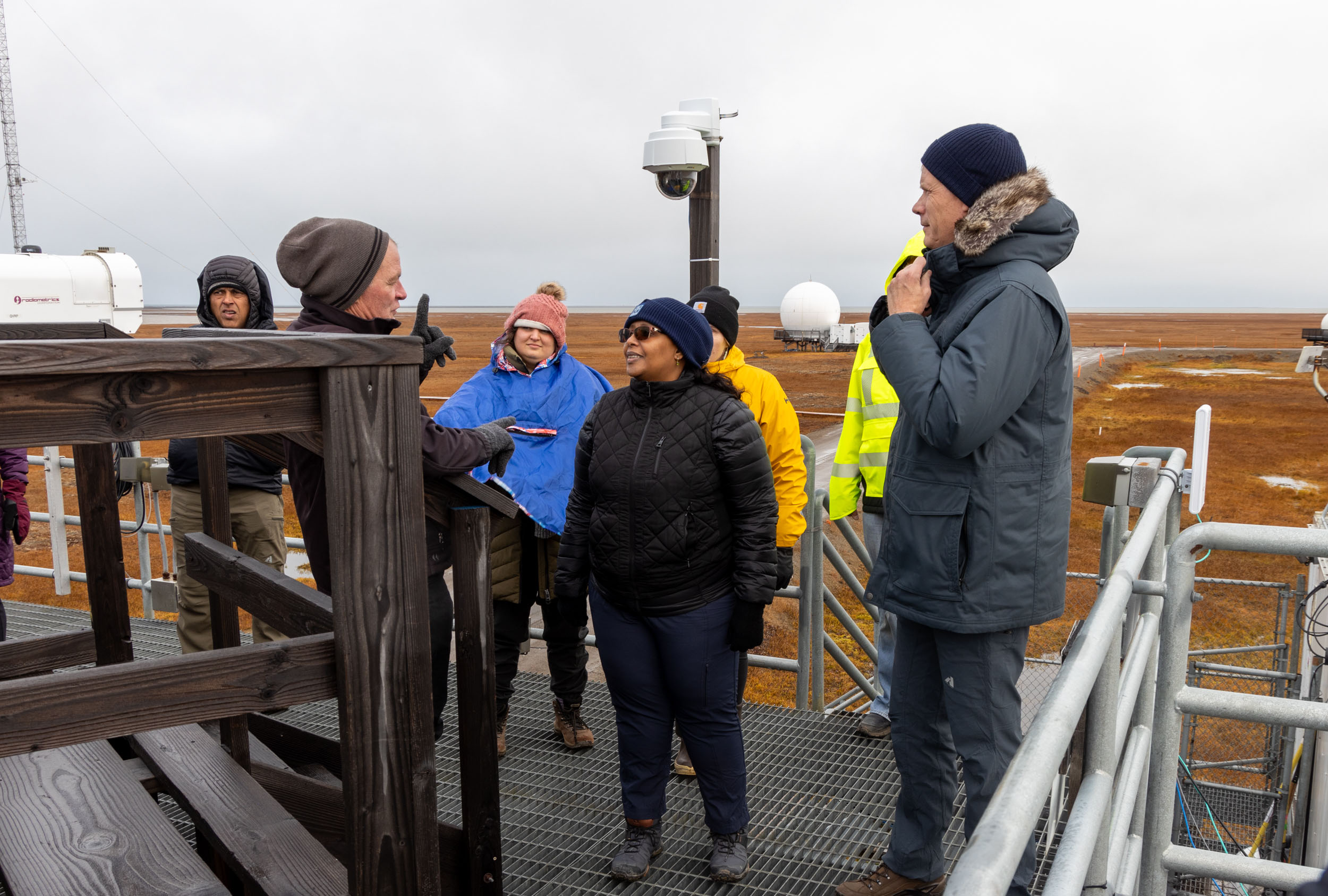 Mark Ivey (left) talks with DOE Office of Science Director Dr. Asmeret Asefaw Berhe (middle) at ARM’s North Slope of Alaska (NSA) atmospheric observatory.