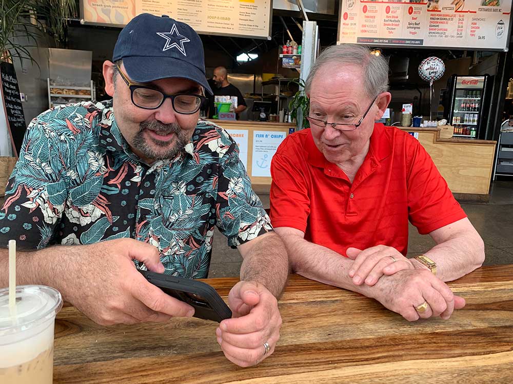 Photo of David Luxat and his father at a table.