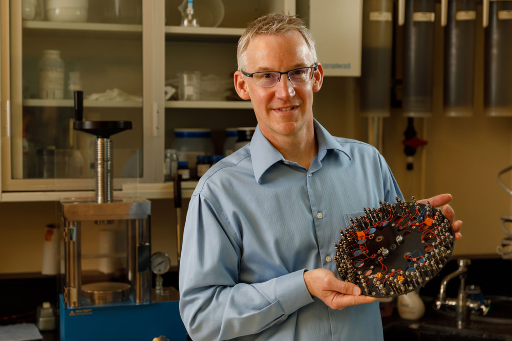 Sandia researcher holds up a device