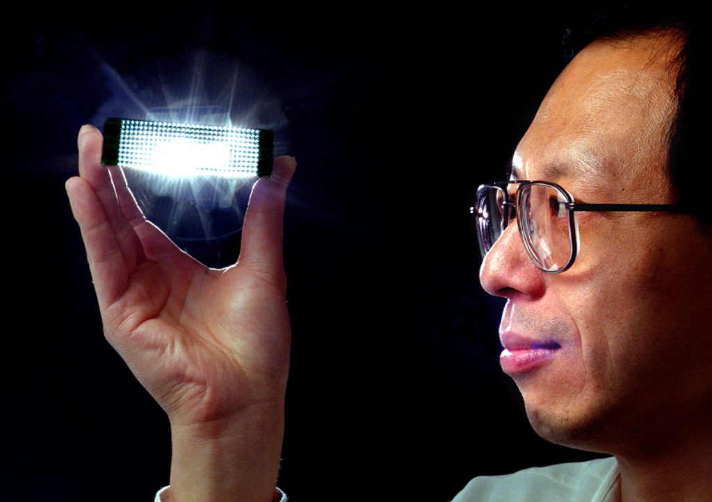 YOU MUST USE THE FORCE ONLY FOR GOOD -- Researcher Shawn Lin at Sandia National Laboratories holds an early prototype of the photonic lattice as light passes through it.