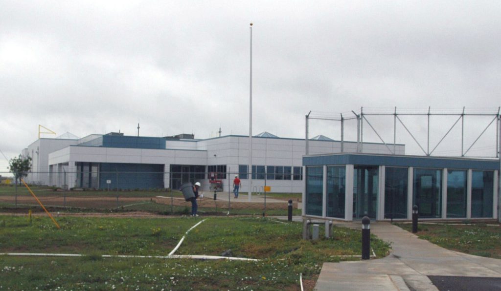 Workmen add finishing touches to the WETL building. This is a view from the front.