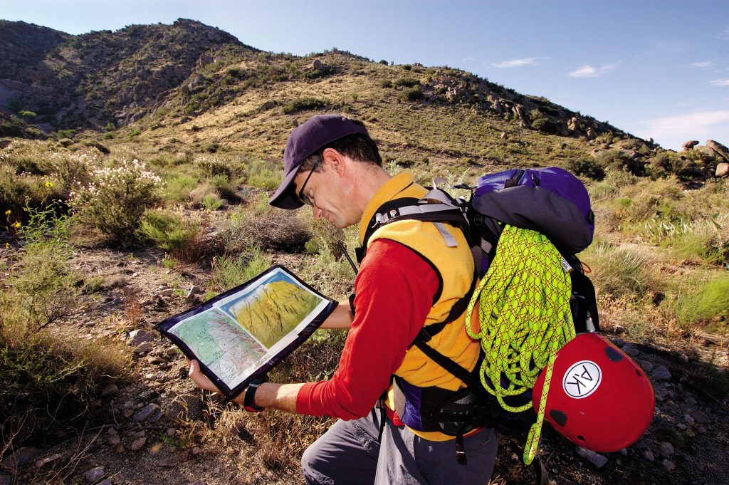 SAR FOR SAR — Sandia researcher Bill Scherzinger, president of the Albuquerque Mountain Rescue Council, looks at a SAR map and a standard topographic map used in search and rescue missions.