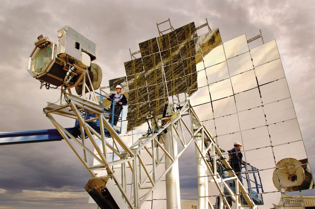 SANDIA RESEARCHER Chuck Andraka makes adjustments to a Stirling Energy Systems, Inc. solar dish-engine system installed at Sandia's National Solar Test Facility earlier this year. Five more will be erected by January as test units.