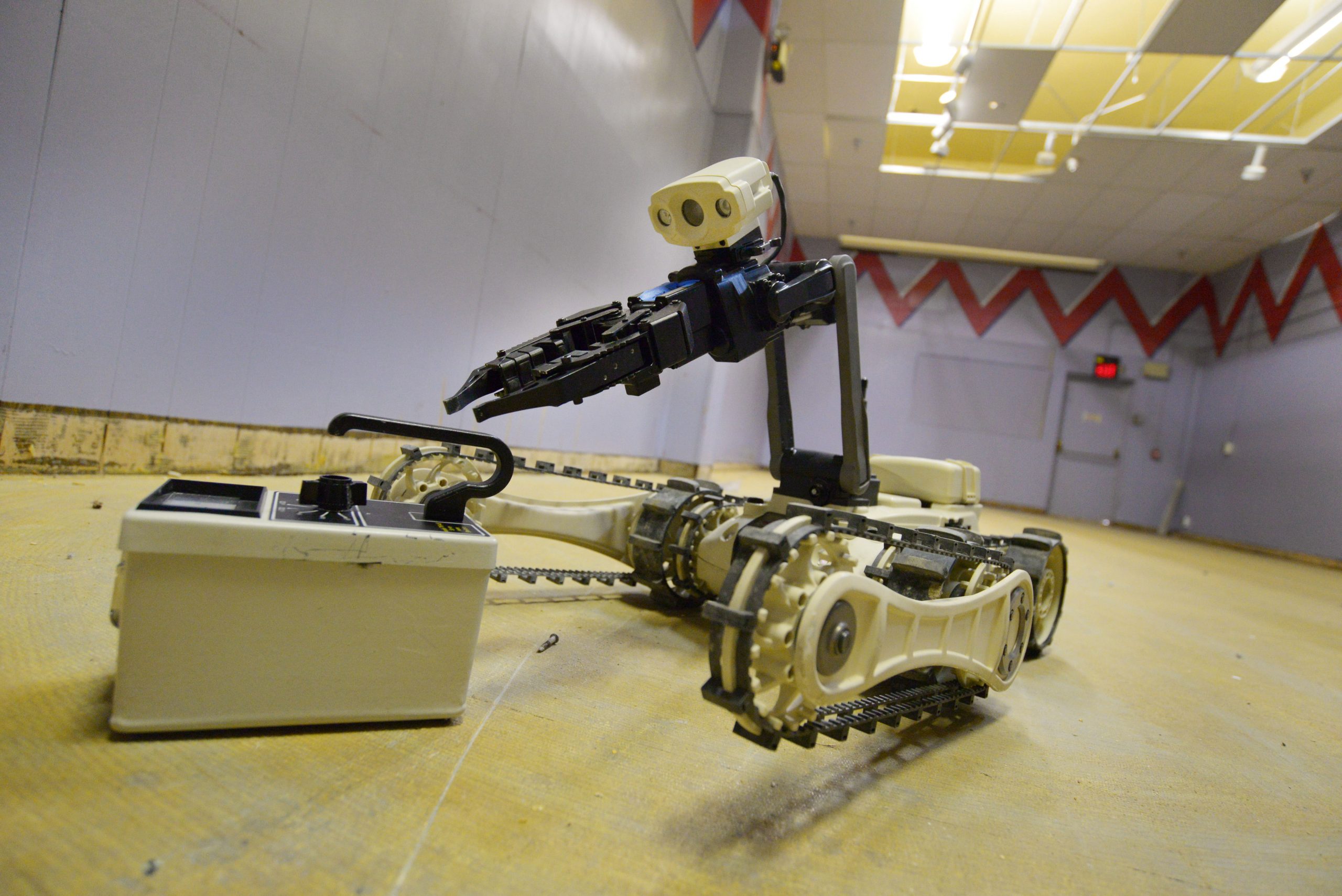 Robot picks up radiation detector during 2015 Robot Rodeo