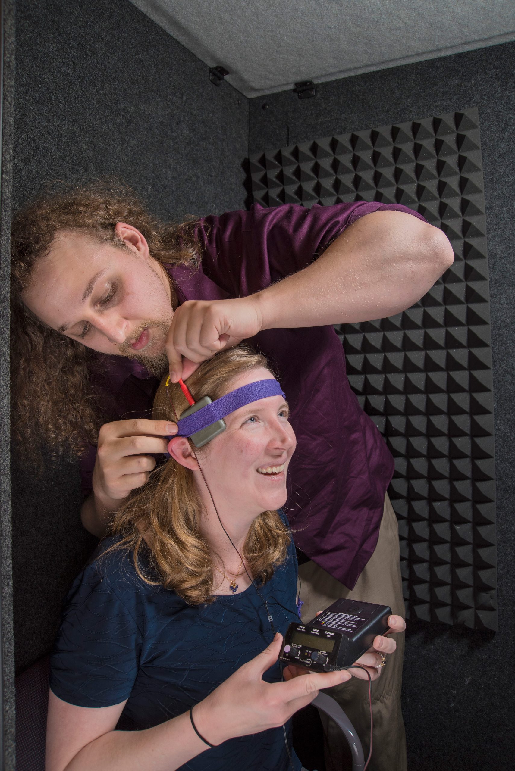 Mike Trumbo adjusts an electrode on Laura Matzen's head