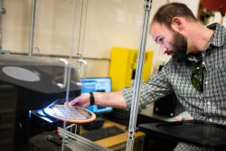 A man examines a semiconductor wafer.