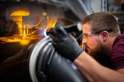 A man peers into a 3D printing machine