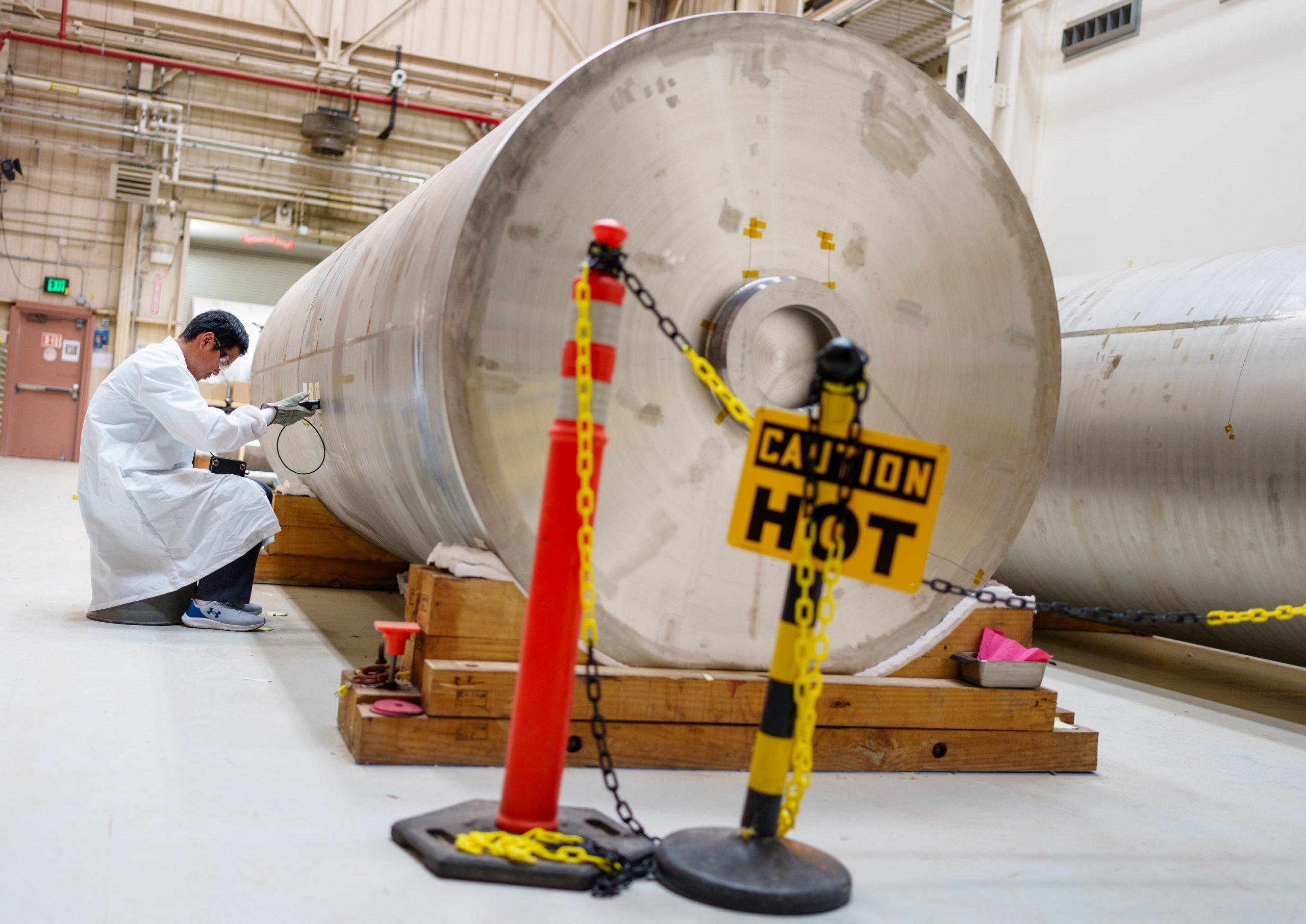 Sandia National Laboratories intern Charles Xu tests the pressure of repair coatings on spent nuclear fuel canisters. Xu is an intern in the Future of Research for Climate, Earth and Energy Institute.