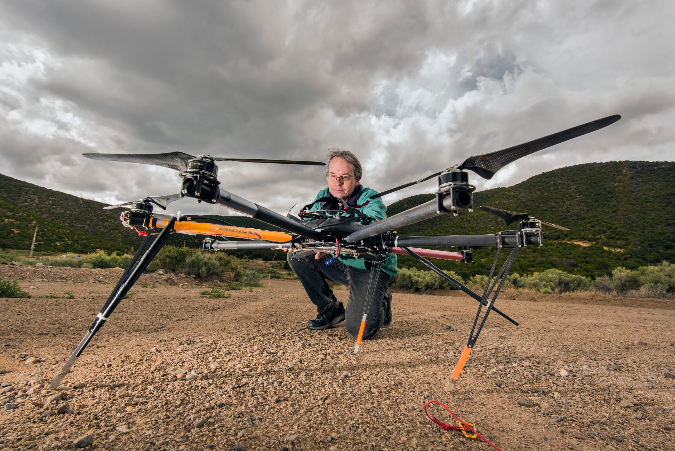 Dave Novick examines an octocopter against a background of grey clouds