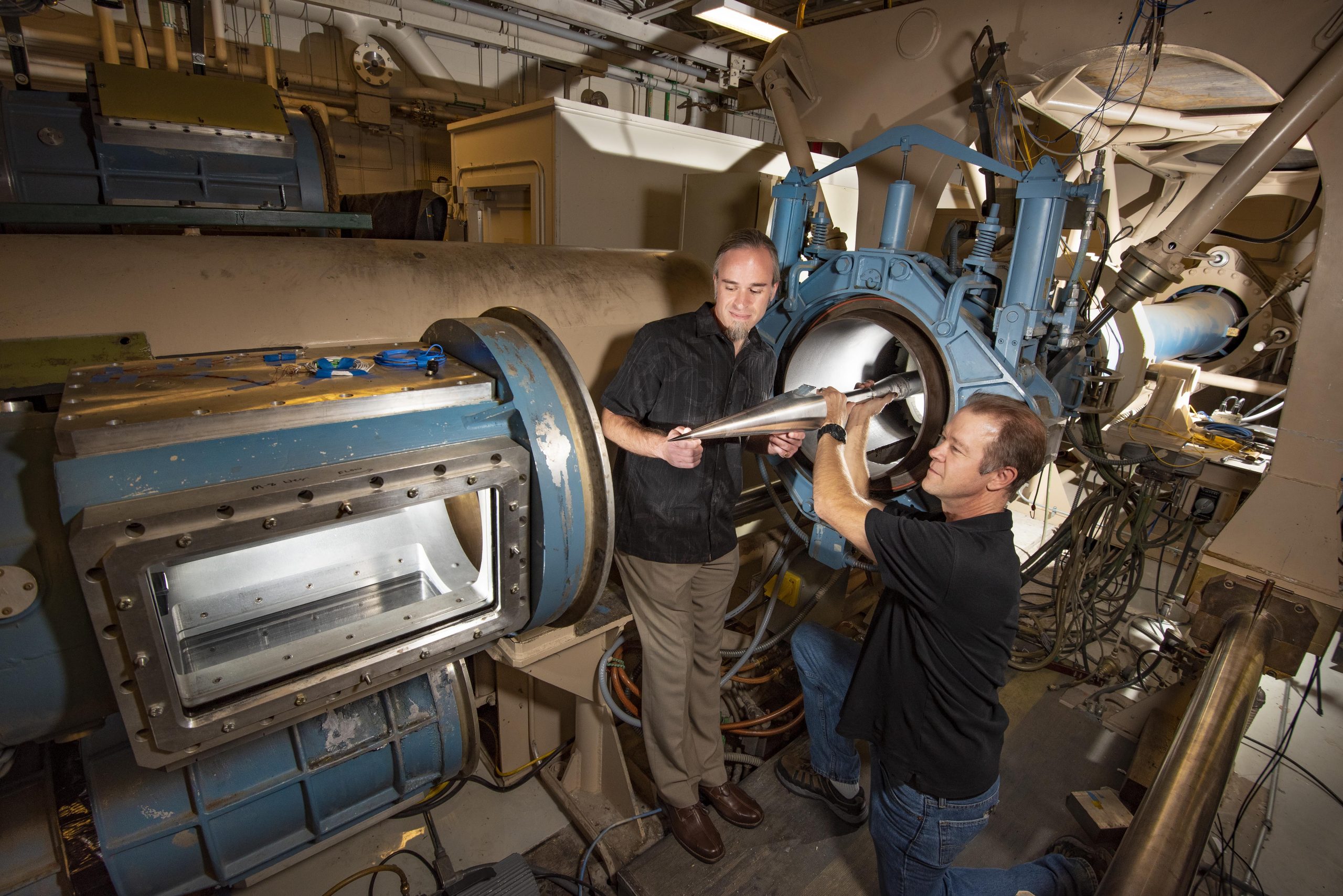 Steven Beresh and Russell Spillers place a model in the hypersonic wind tunnel