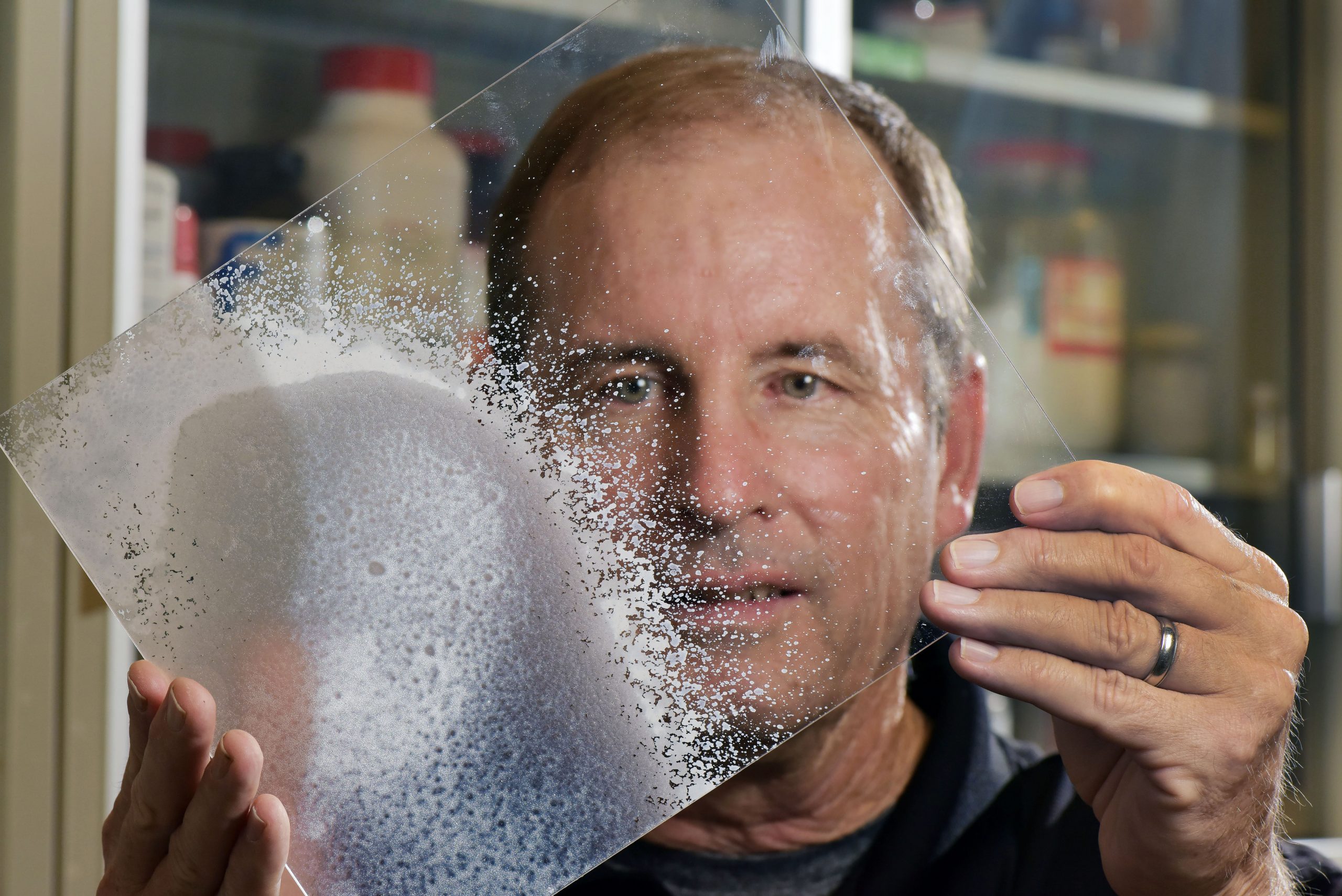 Sandia engineer Mark Tucker with a foam-covered plastic pane.