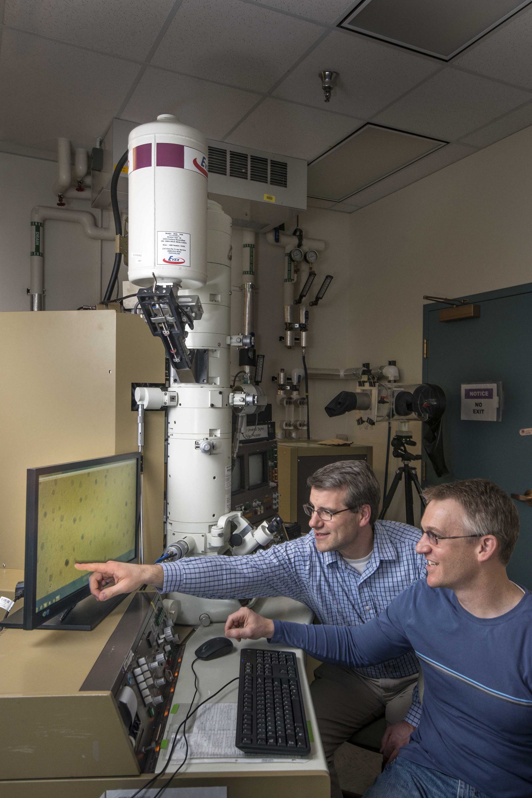 Sandia National Laboratories researchers Dale Huber, left, and Todd Monson have come up with an inexpensive way to synthesize titanium-dioxide nanoparticles, which could be used in everything from solar cells to light-emitting diodes.