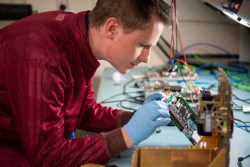 Thomas Bradshaw inspects a computer board