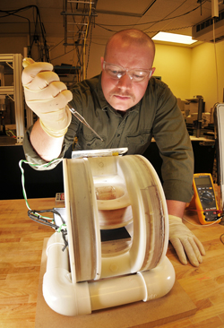 KYLE SOLIS (in photo at left), a graduate student intern in Nanomaterials Sciences Dept. 1112, prepares a sample for mixing using a new approach called vortex field mixing, developed by researchers in his organization. (Photo by Randy Montoya)