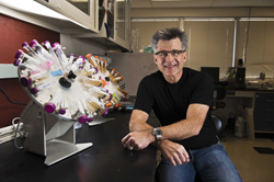 Sandia National Laboratories researcher Jeff Brinker sits next to a cell-suspension wheel that contains bacteria suspended in media. Brinker is also a professor at the University of New Mexico.