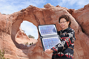 Sandra Begay-Campbell stands in front of Window Rock with a solar panel.