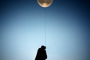 Summer Czarnowski, a geosciences intern at Sandia National Laboratories, holds a line tethered between a scientific payload and a weather balloon prior to launch at Moriarty Airport in New Mexico in July. (Photo by Craig Fritz) Click on the thumbnail for a high-resolution image.