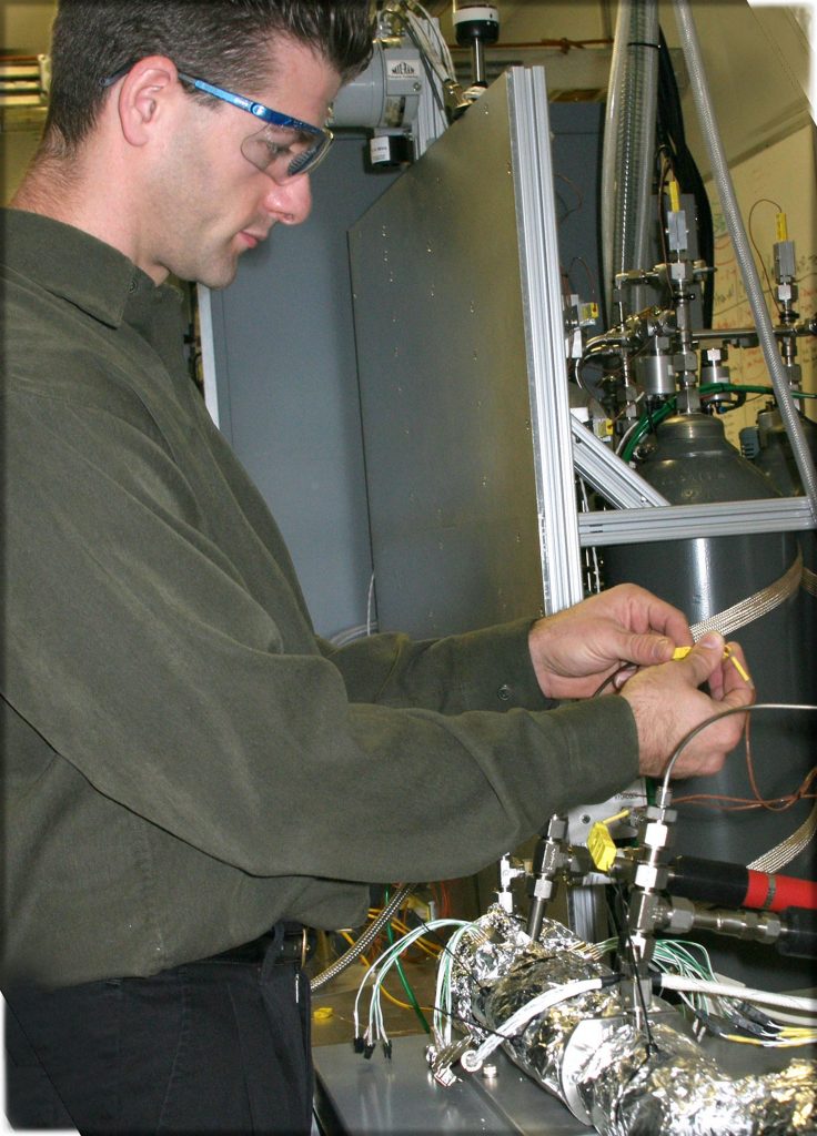 Recharging of the hydrides and release of the hydrogen from metal hydrides such as sodium alanate requires heat, which can reduce overall fuel economy. Sandia National Laboratories engineer Terry Johnson sets up a test apparatus that, when verified, will generate external heat that improves the overall energy density compared to traditional heat sources.