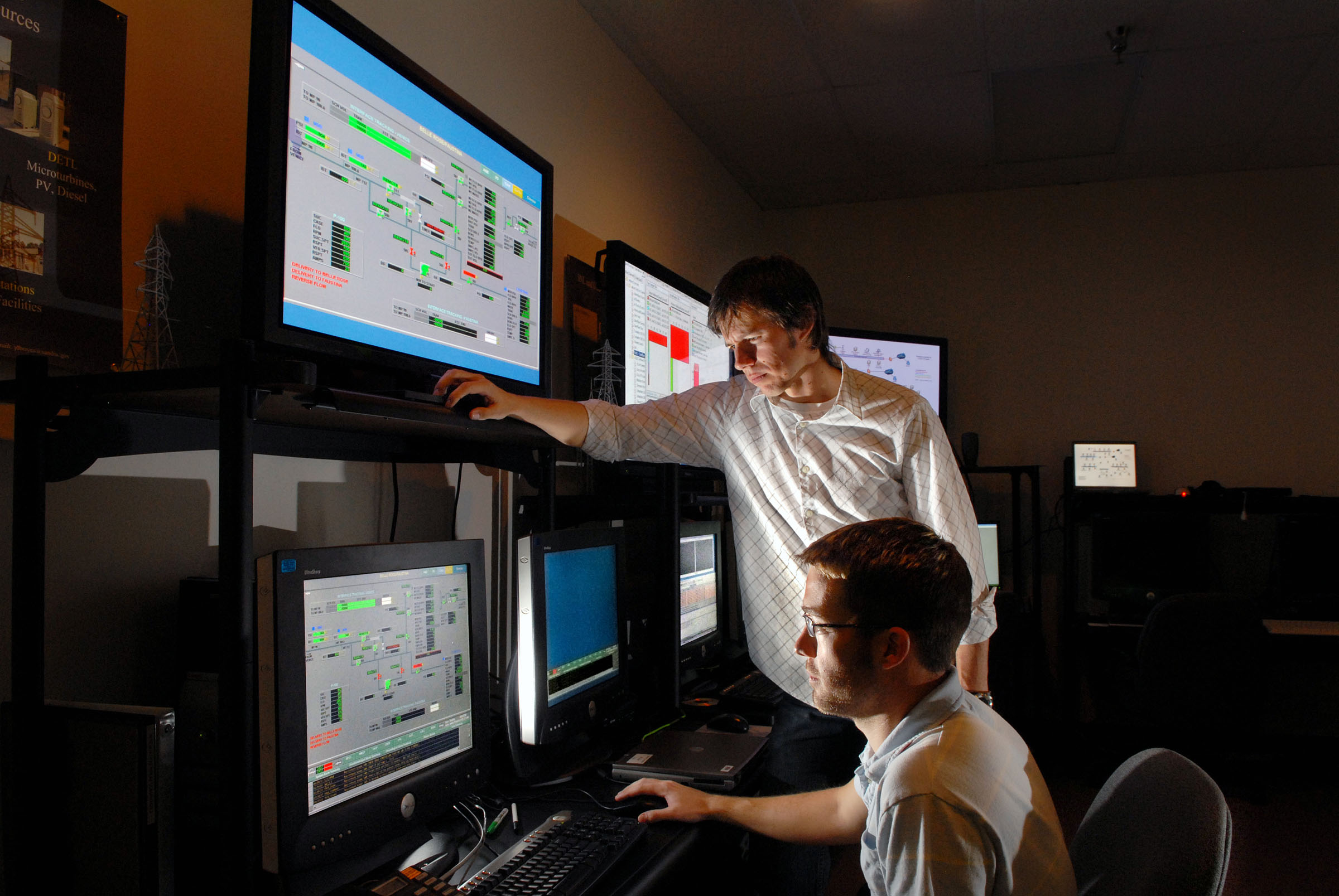 LOGIIC team members Bryan Richardson and Weston Henry demonstrate the project's monitoring solution hosted at Sandia's Center for Control Systems Security.