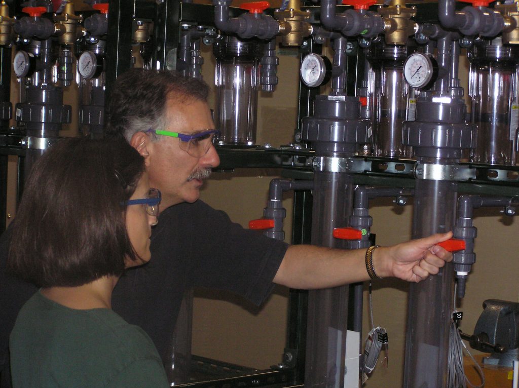 Sandia researchers Malcolm Siegel and Malynda Aragon check out the arsenic treatment system that was built at Sandia and recently relocated to the Desert Sands utility.