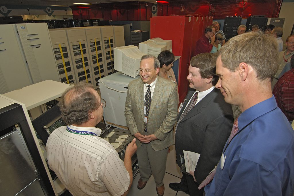 YOU'RE STILL THE ONE — By supercomputer standards, Sandia’s ASCI Red, the world’s first teraflop machine, was ancient, but what a run it had! Here, designer Jim Tomkins (left) talks abuot ASCI Red and its accomplishments with Intel officials Justin Rattner and Stephen Wheat. Rob Leland looks on at right.