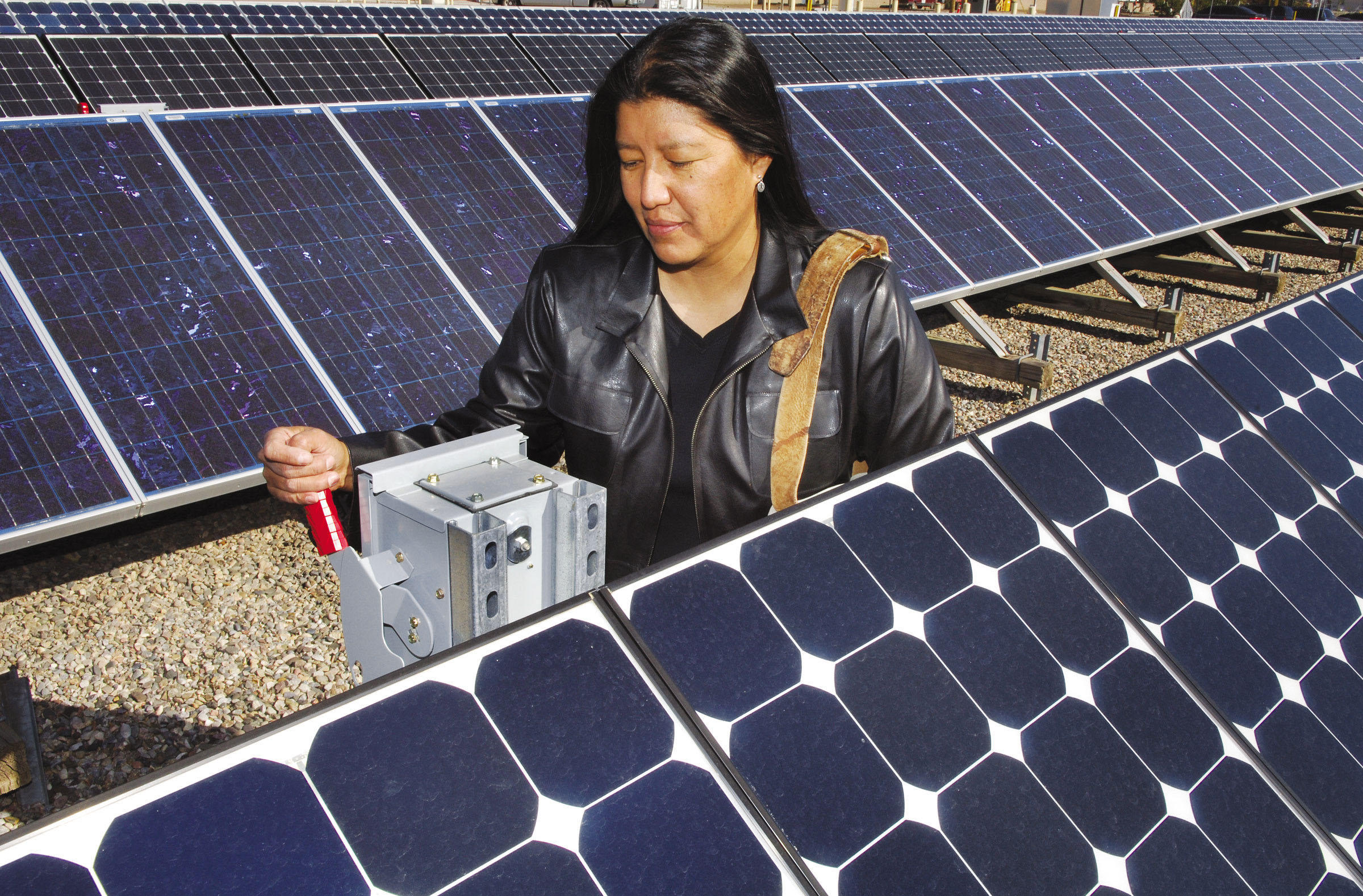 DEBBY TEWA with photovoltaic units at Sandia. She is helping Native Americans in remote areas learn how to maintain PV uits deployed via DOE grant money.