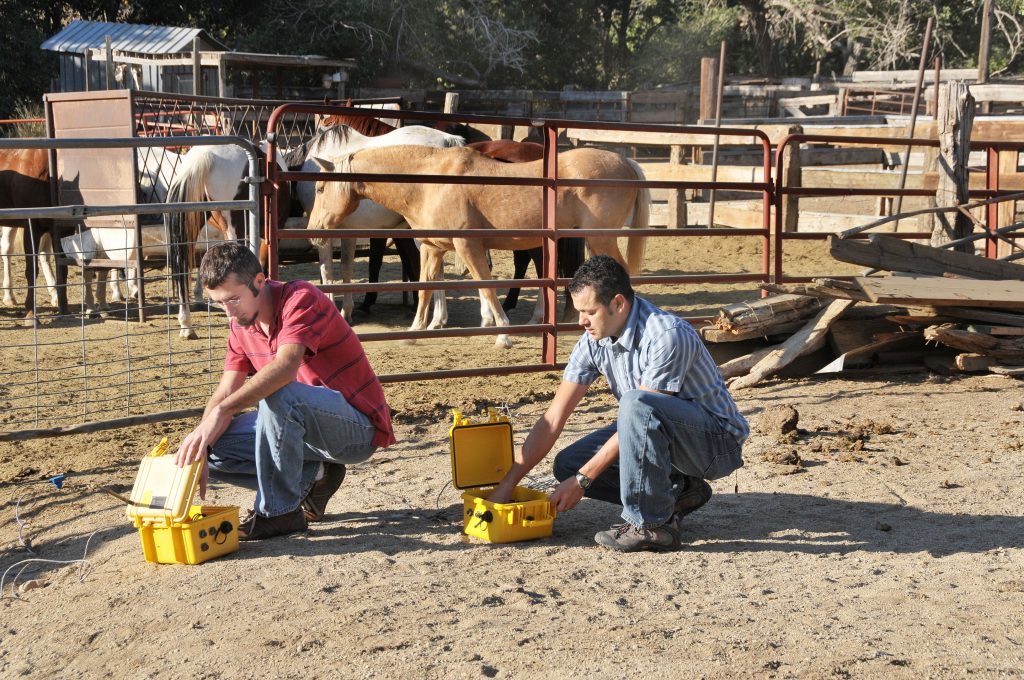 Sandia researchers Josh Jacob, left, and Casey Giron inspect waterproof plastic containers that are part of the remote sensor system they are looking at to help gather wild horses in the Jicarilla Wild Horse Territory. (Photo by Randy Montoya)Download 300dpi 5.44MB JPEG image (Media are welcome to download/publish this image with related news stories.)