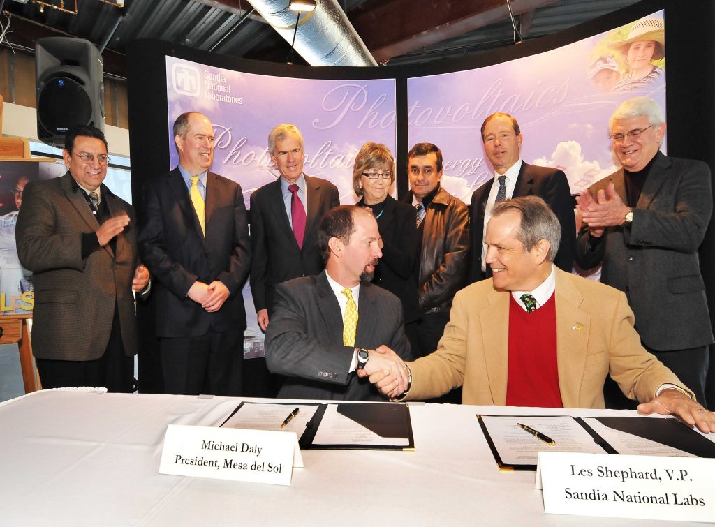 Michael Daly, president of Mesa del Sol, and Les Shephard, Sandia's vice president for Energy, Security, and Defense Technologies, shake hands following the signing of the agreement between Sandia and Mesa de Sol.Behind them (from left to right) are Lenny Martinez, policy advisor for the New Mexico Science and Technology Office; Peter Mitchell, economic development director, City of Albuquerque; U.S. Senator Jeff Bingaman, (D-NM); Lt. Gov. Diane Denish; Dennis Garcia, assistant commissioner New Mexico State Land Office; Rep. Tom Udall (D-NM); and Fred Mondragon, New Mexico economic development secretary. (Photo by Randy Montoya)Download 300dpi 500 KB JPEG image (Media are welcome to download/publish this image with related news stories.)