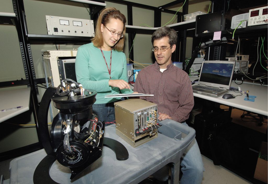 HOW SWEET IT IS — Researchers April Sweet and Michael Holzrichter examine a miniSAR package similar to the configuration that has flown for the first time on a Twin Otter aircraft.