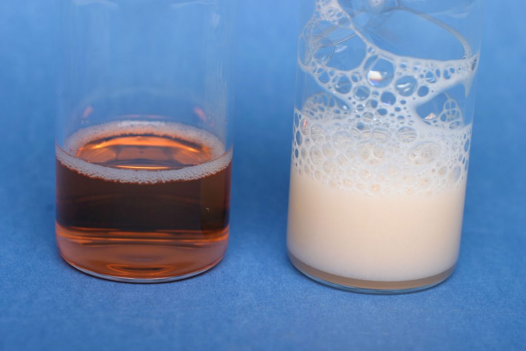 Left, a cleavable surfactant in aqueous solution dissolves an oil-soluble dye. Right, that same system forms an emulsion when oil is added.