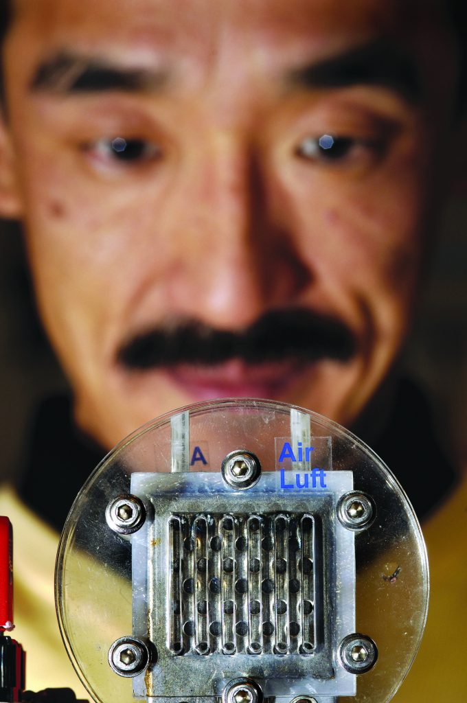 FUEL CELL FOCUS — Sharp Corporation researcher Akimasa Umemoto looks at a prototype miniature fuel cell stack.