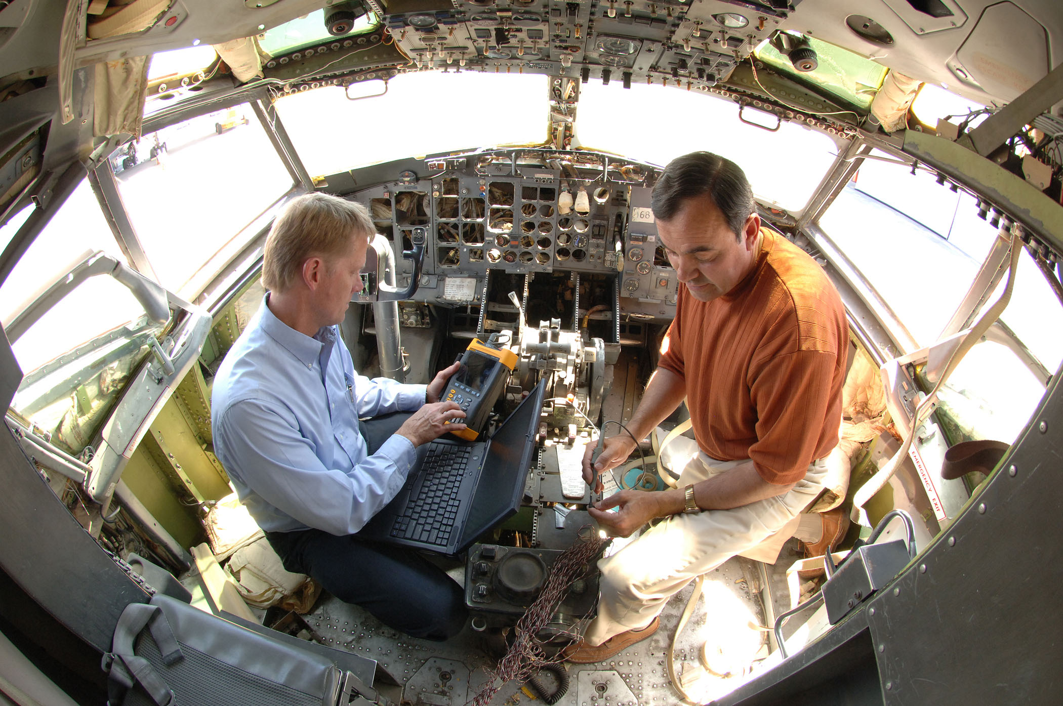 Mike Dinallo and Larry Schneider (left) prepare to employ the PASD diagnostic on a wiring bundle in the cockpit of a retired Boeing 737 at Sandia’s FAA Airworthiness Assurance NDI Validation Center.