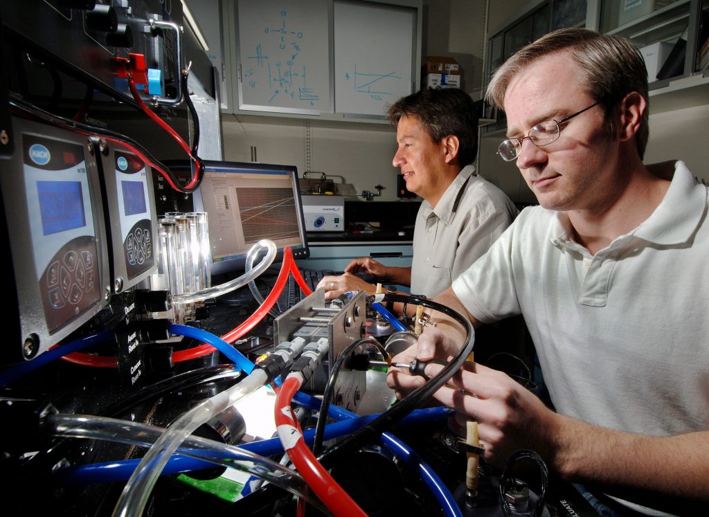 A BETTER ELECTRODIALYSIS SYSTEM — Sandia researchers Michael Hibbs, foreground, and Chris Cornelius check out an electrodialysis system that removes salt from water with an electric field and special ion exchange membranes. This technology is one that will be included in the final Desalination and Water Purification Roadmap being developed by Sandia.