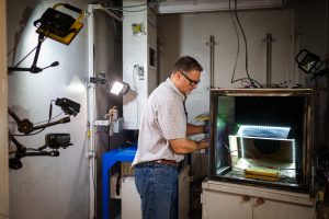 Sandia National Laboratories' Genaro Quintana prepares a battery for testing in a vault at the Battery Abuse Testing Lab. Sandia's research on detecting battery failures sooner in electric vehicles was published in the Journal of the Electrochemical Society. (Photo by Craig Fritz) Click on thumbnail for a high-resolution image. 