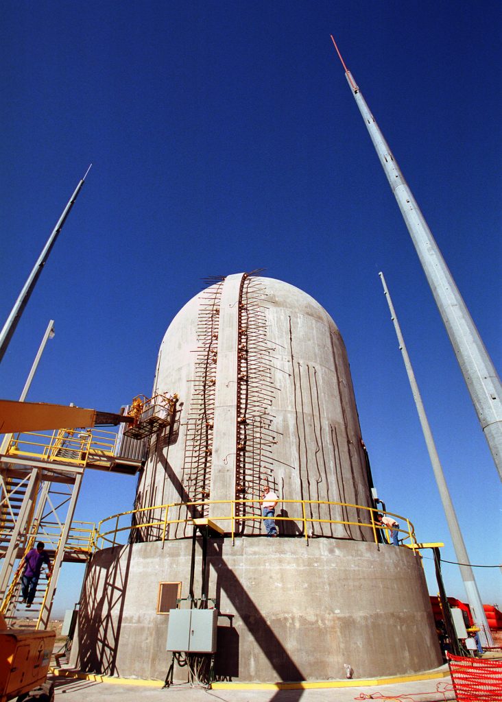 Researchers map cracks on the surface of a 70-ft.-high prestressed concrete containment vessel (PCCV) in preparation for a test, during which the structure will be subjected to increasing gas pressure until it fails. The PCCV, built during the last three years at a remote Sandia test area, is a 1/4-scale model of a containment vessel at an operating nuclear power plant in Japan.