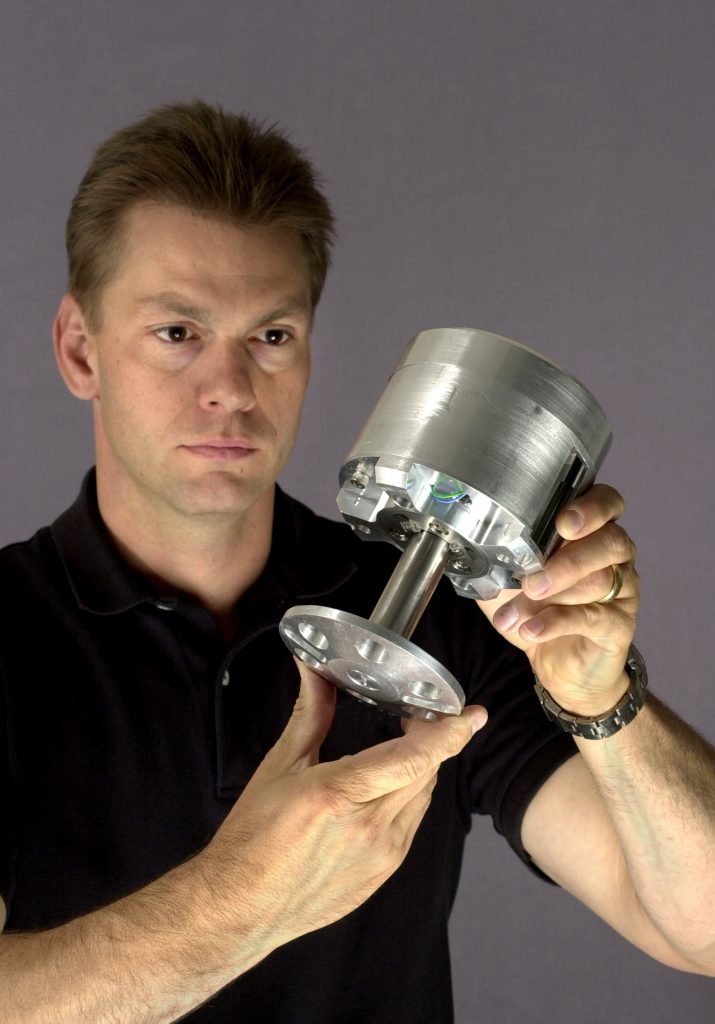 Sandia National Laboratories researcher Gary Fischer with one of the combustion-powered hopping robots developed by Sandia for the Defense Advanced Research Projects Agency.