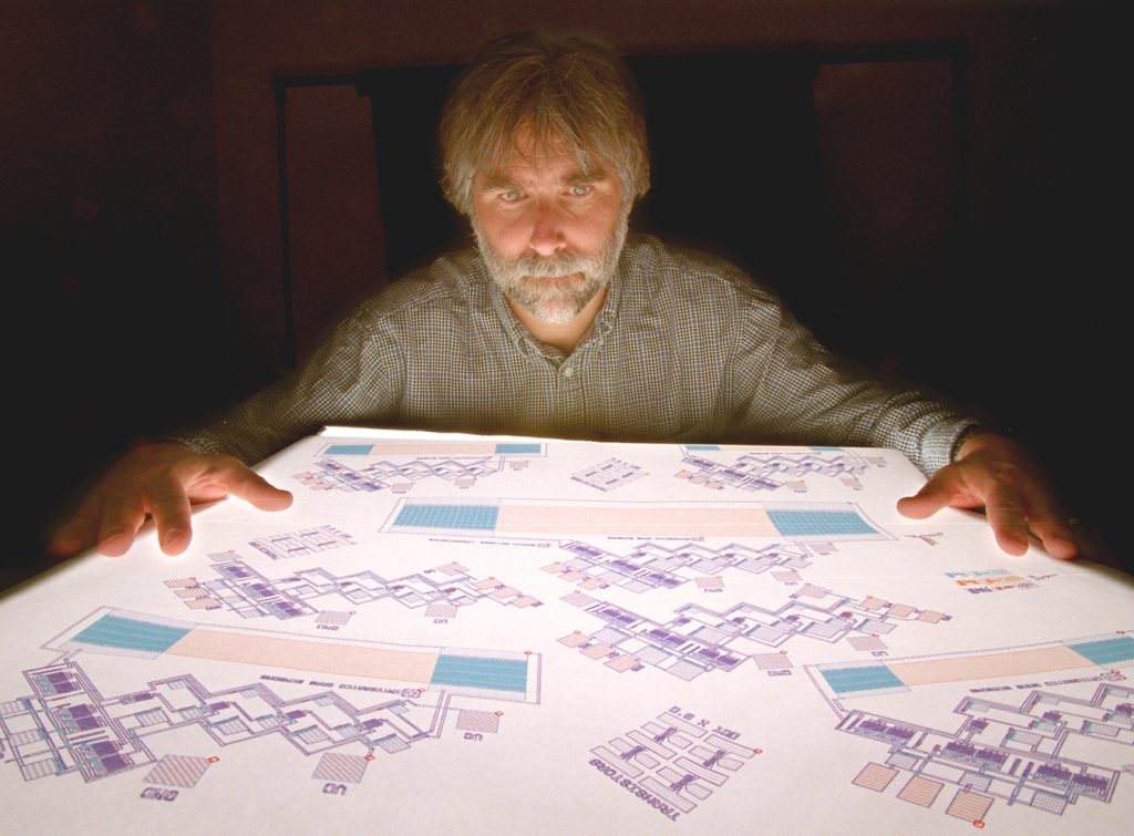 SENSOR DESIGN -- Steve Casalnuovo shows a large computer printout of the design of the acoustic wave sensor.