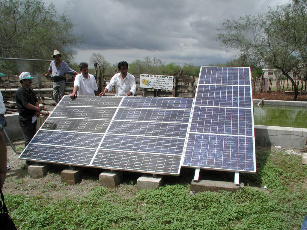 Officials of FIRCO and CONAE (the Mexican National Commission for Energy Savings) discuss the recent installation of a photovoltaic water-pumping station on Rancho Sagitario in Baja California Sur, just outside of La Paz. The ranch manager is standing in the background (in the hat). (From left: Oscar Sandoval, Regional Director of CONAE in Chihuahua; ranch manager, name not known; Jesús Parada, FIRCO, Chihuahua; and Simón Ortiz, FIRCO, Baja California Sur.)