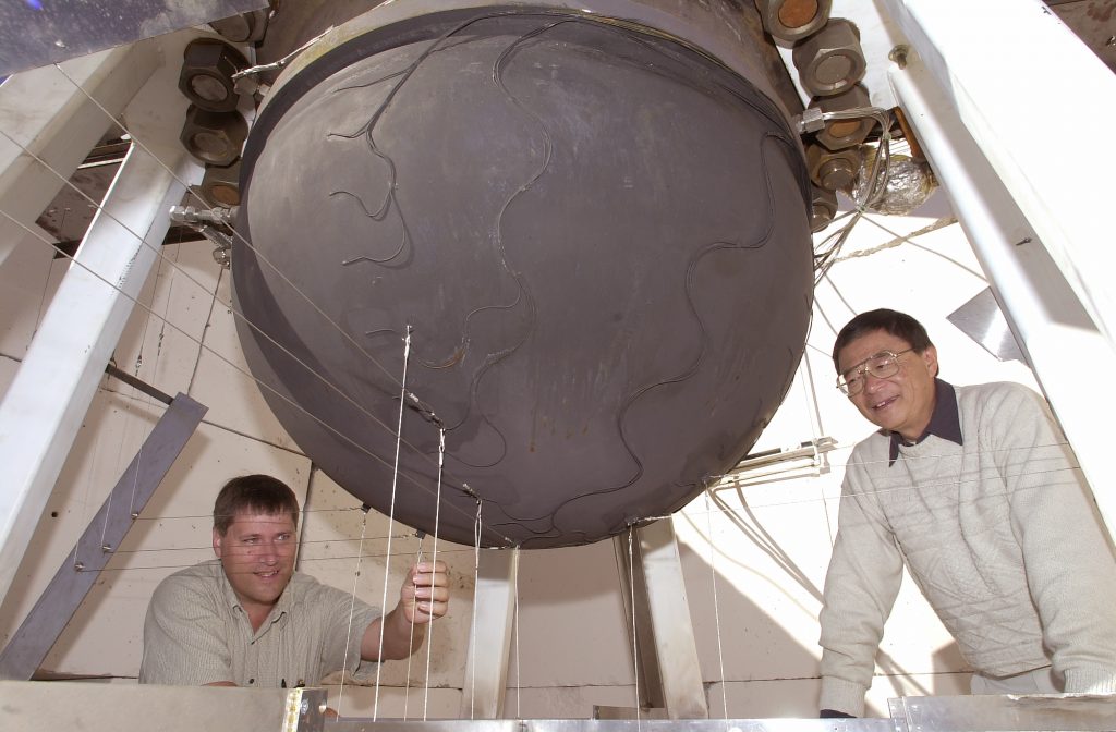 Sandia National Laboratories test engineers Larry Humphries (left) and T.Y. Chu inspect the underside of a 1/5-scale model lower-head assembly in preparation for a "test to failure" involving high temperatures and pressures.