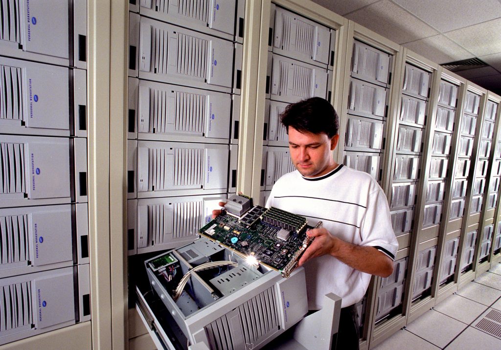 NOT A MAGIC LANTERN, BUT CLOSE — Ron Brightwell (9223), examines the motherboard of one of Cplant's computers. The board is out of a Digital personal workstation 500A. Digital is now owned by Compaq Computer Corp.