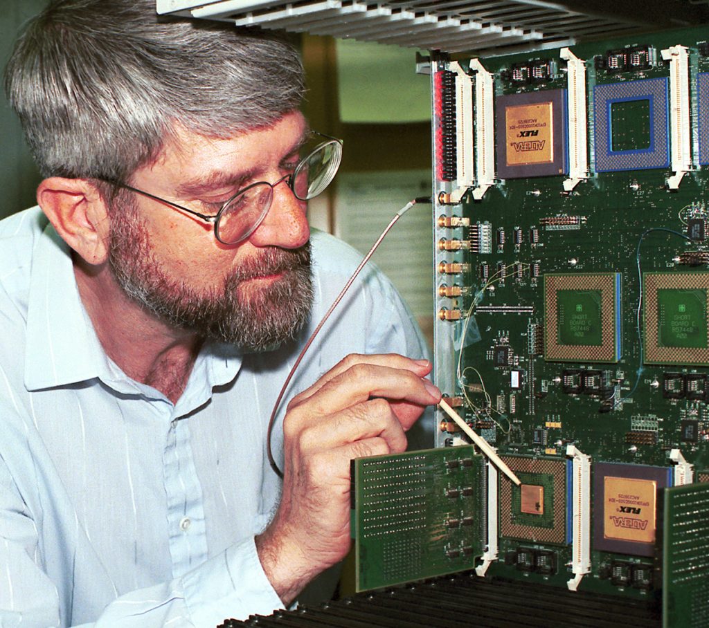 LYNDON PIERSON points to the unclassified encryptor chip -- the world's fastest encryption device -- that his Sandia National Laboratories research team designed.