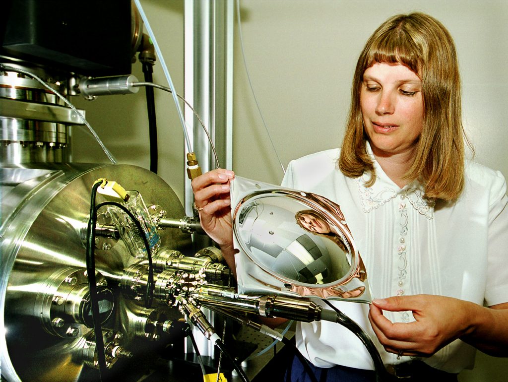 NEW APPROACH TO SPACE MIRRORS — Sandia researcher Tammy Henson examines a thin-film ultralight piezoelectric material. She and other researchers are studying the control of the material for future use in space telescopes and surveillance satellites.